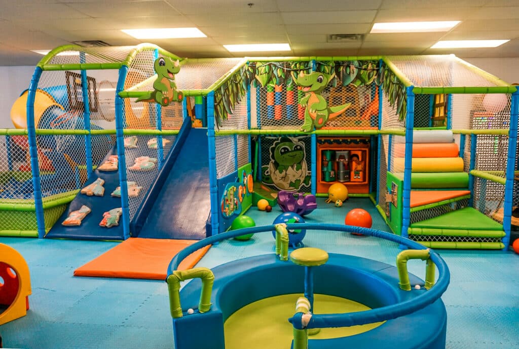 Dino Kidz—A dinosaur themed indoor playground in Dallas. It has a wide blue slide, merry-go-round, a spiral slide into a ball pit and more.