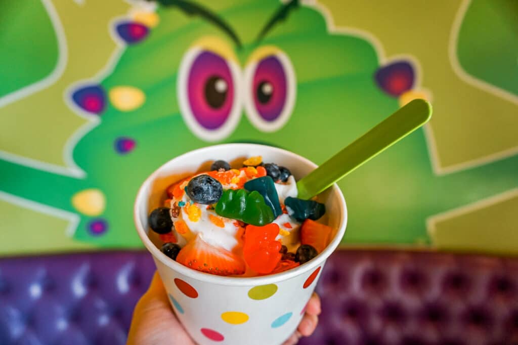A cup of frozen yogurt with fresh blueberries, strawberries, and gummy bears from Monster Yogurt in Dallas.