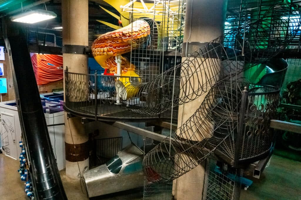 An industrial looking indoor playground with a drop slide at SPARK! Dallas.