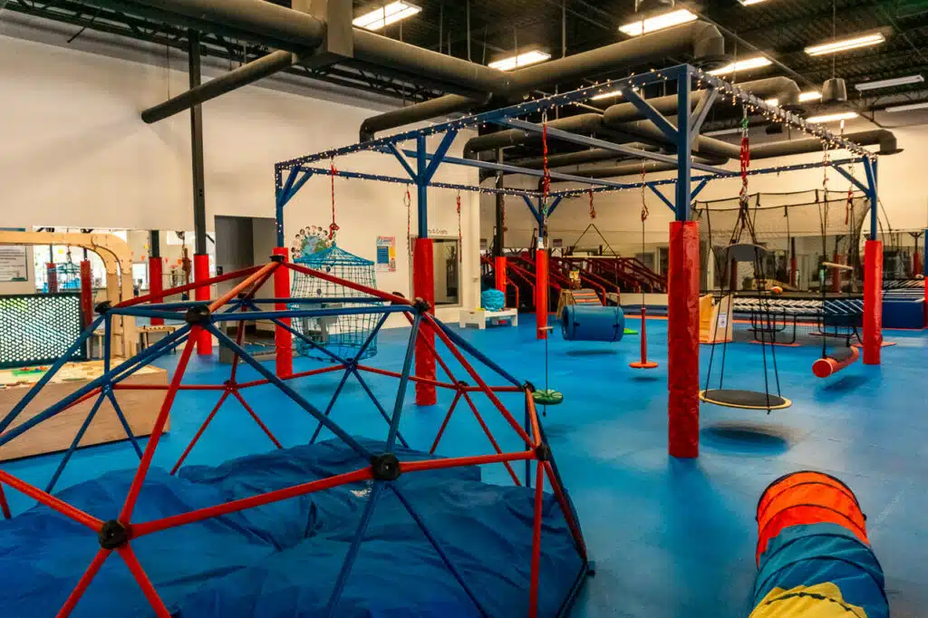 The ultimate kid's indoor play gym at We Rock The Spectrum in Dallas. A climbing dome, sentry swings, zip lines, crawling tunnels, and more.