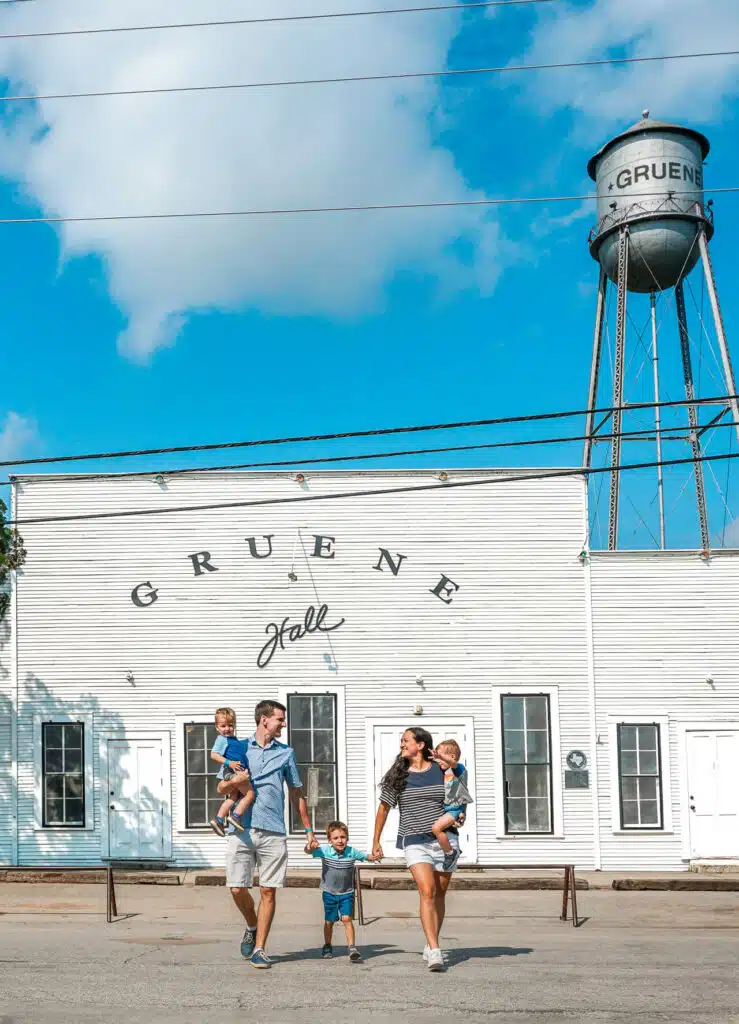 A family with three boys walking across the street in front of the historic Greune Dance Hall in New Braunfels. 