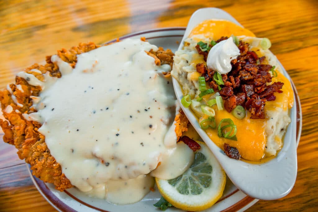 A favorite dish of Chicken Fried Steak with Loaded Mashed Potatoes from Gristmill River Restaurant. 