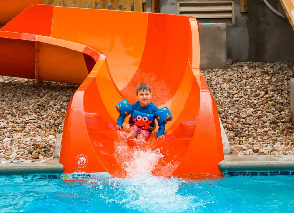 A kid riding an orange-red waterslide at Schlitterbahn - one of the best things to do in New Braunfels with kids.