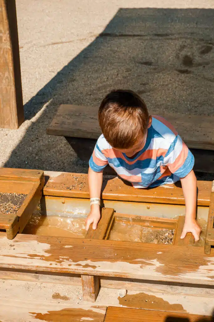 A young boy panning for fossils at Beavers Bend Mining Company—one of the best things to do in Broken Bow with kids. 