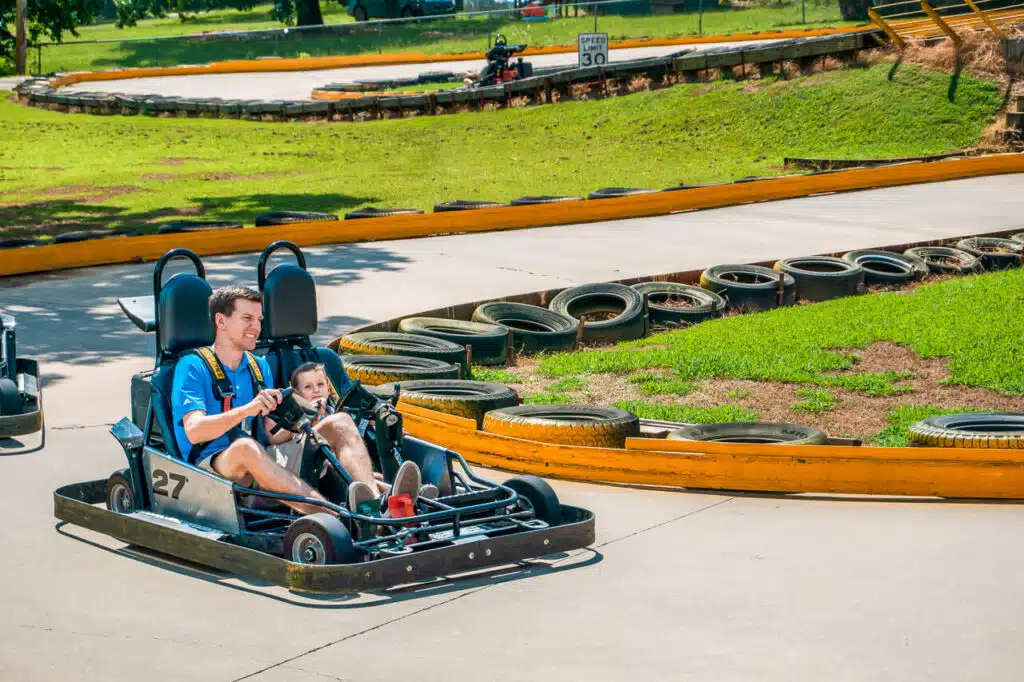 A dad and his young son driving a go-kart at Hochatown Amusements in Broken Bow, Oklahoma.