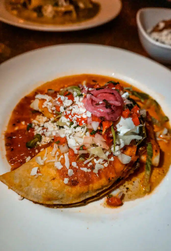 A half-moon shaped beef enchilada topped with vibrant ingredients at Elote Cafe in Sedona. 