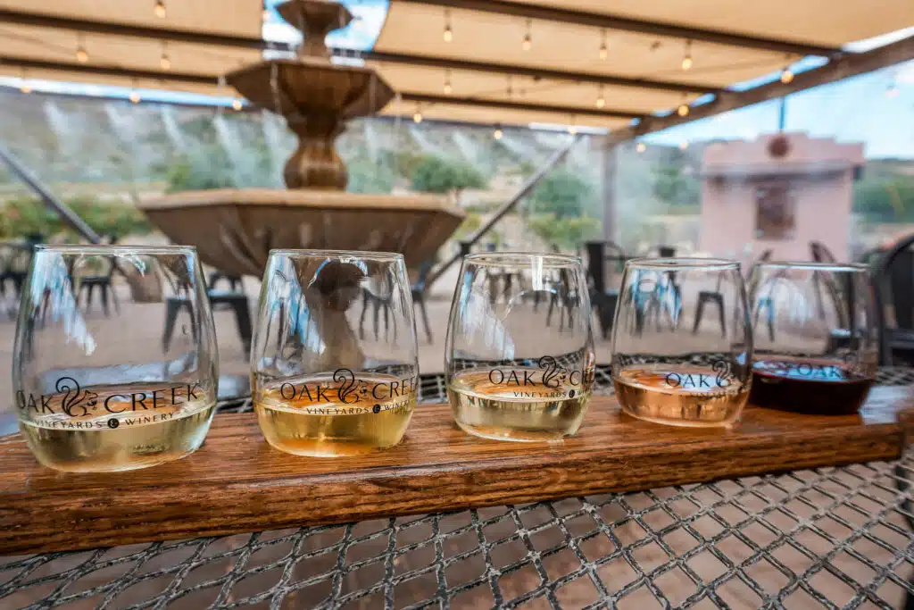 A wine flight of white wines and a dark red wine at the end from Oak Creek Vineyards and Winery. 