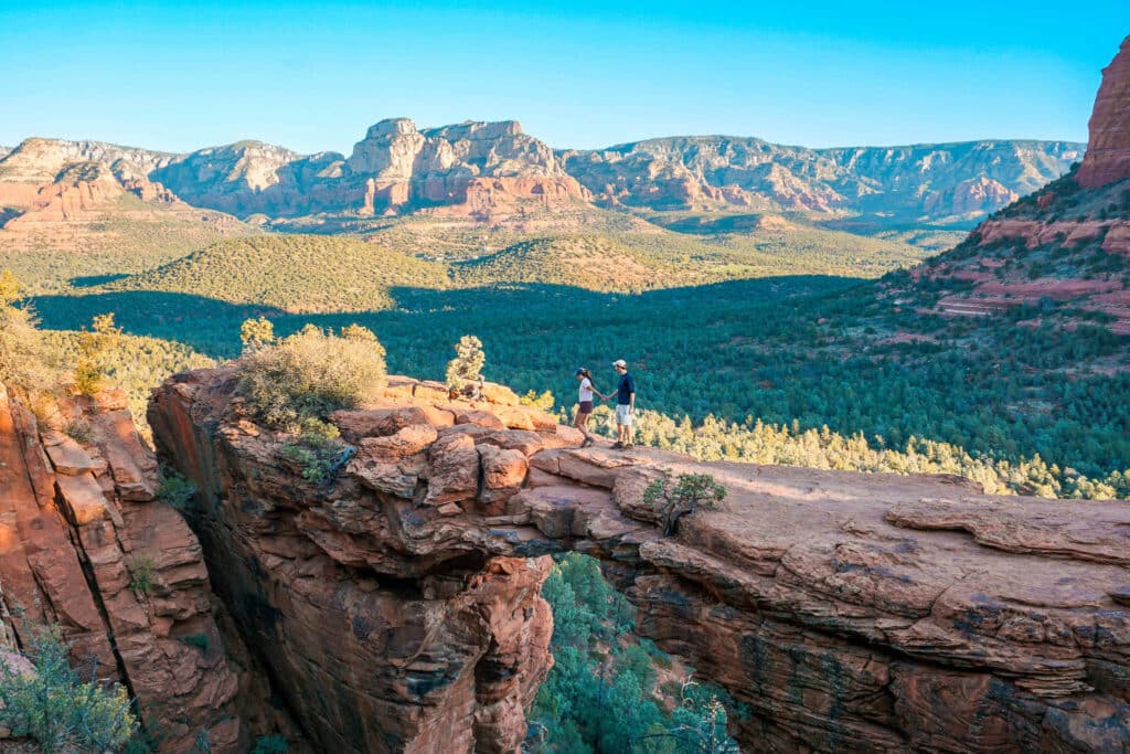 A couple holding hands walking across the iconic Devil's Bridge in Sedona. 